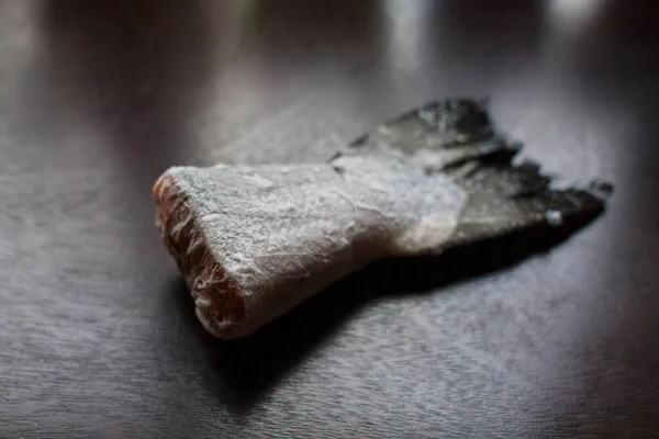 Frozen salmon tail on dark kitchen table — Stock Image Frozen Salmon Tail Dark Kitchen Table Stock Picture
