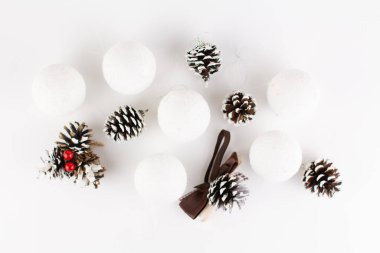 Noel oyuncakları beyaz arka planda çam kozalakları ve toplar