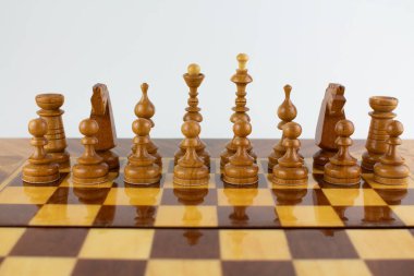 Beyaz üzerine tahta parçalardan yapılmış bir satranç tahtası.