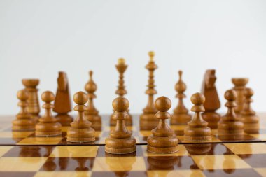 Beyaz üzerine tahta parçalardan yapılmış bir satranç tahtası.