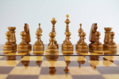 Beyaz üzerine tahta parçalardan yapılmış bir satranç tahtası.