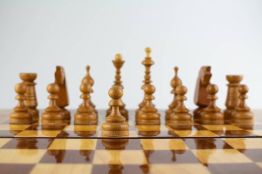 Beyaz üzerine tahta parçalardan yapılmış bir satranç tahtası.