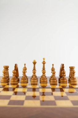 Beyaz üzerine tahta parçalardan yapılmış bir satranç tahtası.