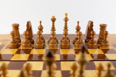 Beyaz üzerine tahta parçalardan yapılmış bir satranç tahtası.
