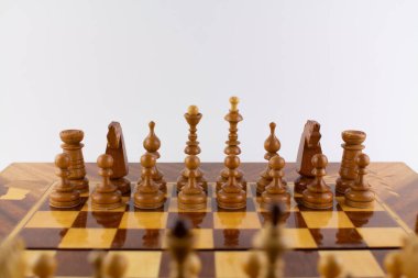 Beyaz üzerine tahta parçalardan yapılmış bir satranç tahtası.