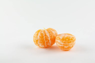 Beyaz bir zemin üzerinde soyulmuş güzel bir mandalina.
