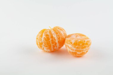 Beyaz bir zemin üzerinde soyulmuş güzel bir mandalina.