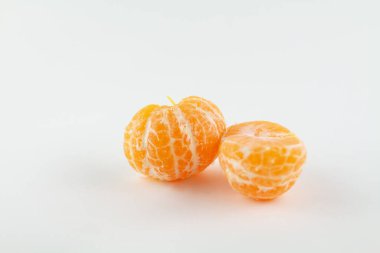 Beyaz bir zemin üzerinde soyulmuş güzel bir mandalina.