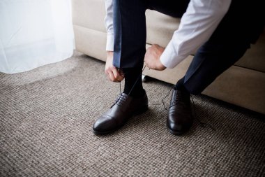 # Adam bağcıklarını bağlar sabahleyin, odada #