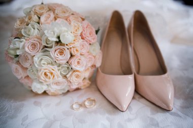 Altın yüzüklü ve buketli gelin ayakkabısı.