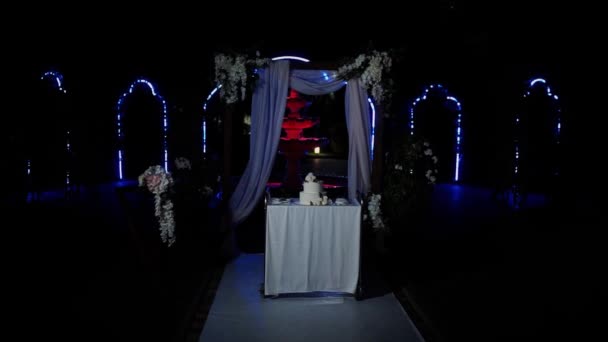 Свадебный Торт Вечером Возле Свадебной Арки — стоковое видео