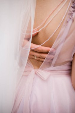 Damadın eli gelinin sırtında. Gelinlik giymiş.