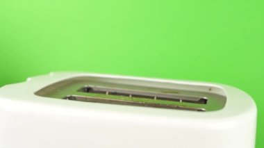 Kızarmış ekmek kızartma makinesinde kızartılmış yeşil arka planda.