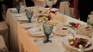 Bir restoranda yemek ve gözlüklü bir düğün masası.