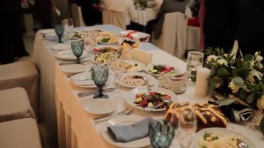 Bir restoranda yemek ve gözlüklü bir düğün masası.