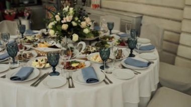 Bir restoranda yemek ve gözlüklü bir düğün masası.