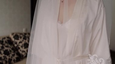 Gelinin gelinliği odadaki avizeye asılı.