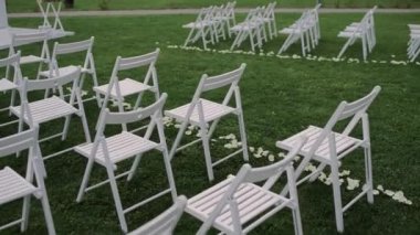 Parkta beyaz sandalyeli güzel bir düğün kemeri