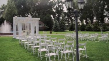 Parkta beyaz sandalyeli güzel bir düğün kemeri