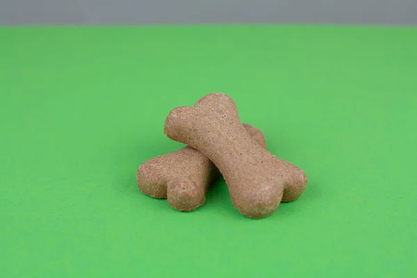 Yeşil arka planda köpek maması kemikleri.