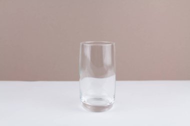 Mutfakta beyaz kahverengi arka planda cam bir bardak var.