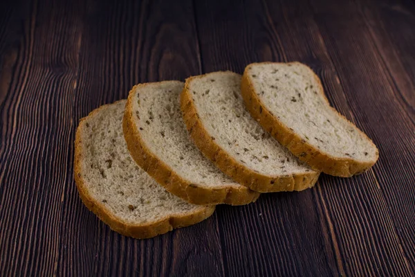 Ein Geschnittenes Brot Auf Einem Dunklen Holztisch — Stockfoto