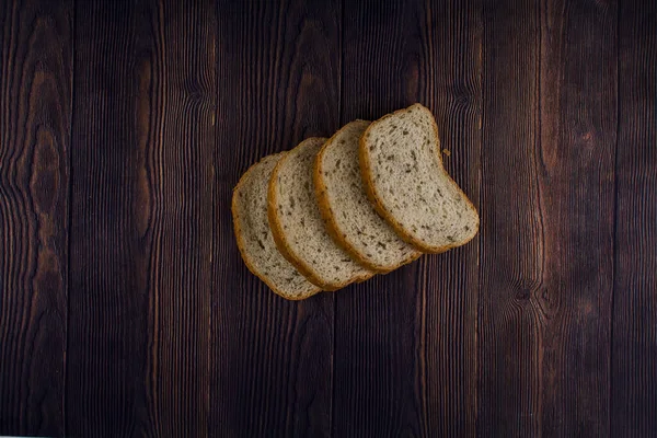 Koyu Ahşap Bir Masada Dilimlenmiş Bir Ekmek — Stok fotoğraf