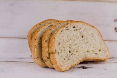 Ahşap bir masada dilimlenmiş bir ekmek.