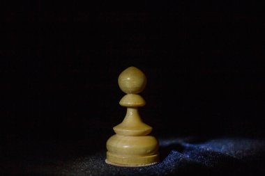 Siyah arka planda tahta bir satranç piyonu