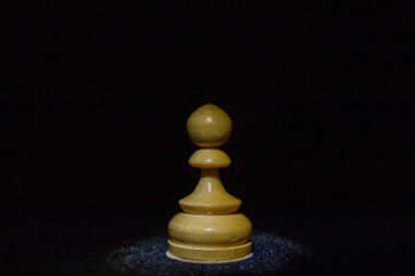 Siyah arka planda tahta bir satranç piyonu