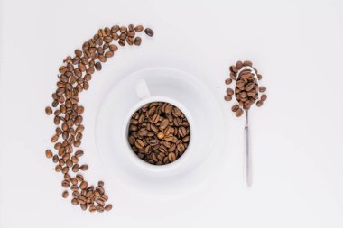 Beyaz arka planda kahve çekirdekleri olan bir kahve fincanı.