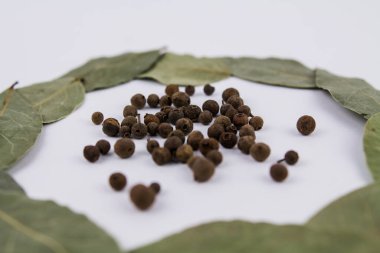 Beyaz arka planda tatlı bezelyeler olan bir defne yaprağı.