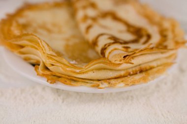 Mutfak masasının üzerinde un, çırpı ve yumurta dolu yuvarlak, güzel bir krep.