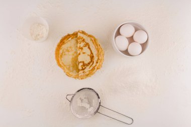 Tavuklu ince yuvarlak krep ve beyaz tabakta un.