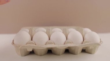 Beyaz arka planda karton tepside taze çiğ tavuk yumurtası.
