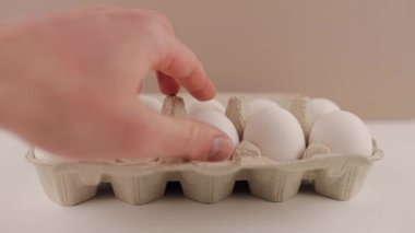 Beyaz arka planda karton tepside taze çiğ tavuk yumurtası.