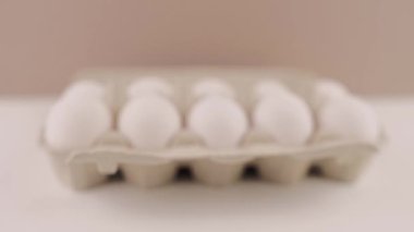 Beyaz arka planda karton tepside taze çiğ tavuk yumurtası.