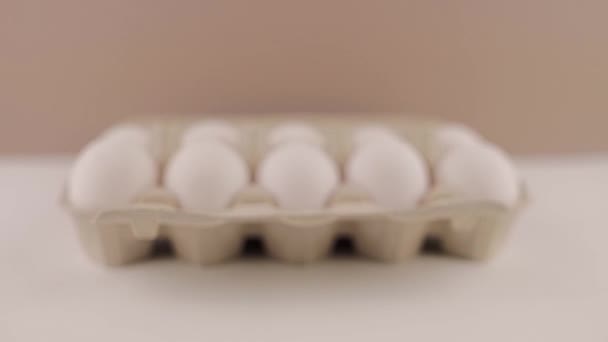 在白色背景的纸板盘上的新鲜生鸡蛋 — 图库视频影像