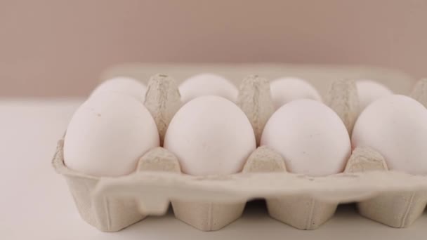 在白色背景的纸板盘上的新鲜生鸡蛋 — 图库视频影像