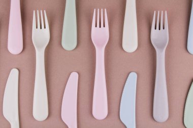 Farklı renklerde plastik çatal bıçak seti mutfak masasında çatal bıçak ve çevre dostu plastik.
