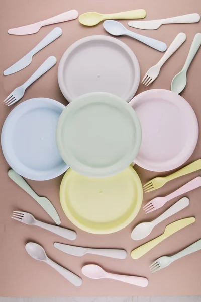 set of plastic colored dishes with a plate fork spoon knife on the table eco-friendly tableware