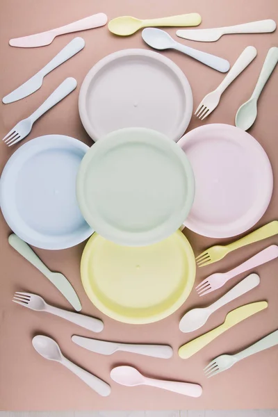 set of plastic colored dishes with a plate fork spoon knife on the table eco-friendly tableware