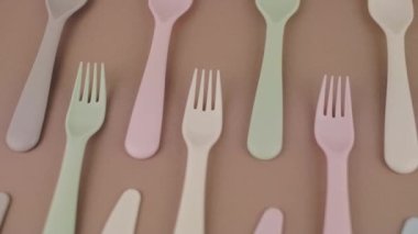 Farklı renklerde yeniden kullanılabilir plastik çatal bıçak seti mutfak masasında çatal bıçak.