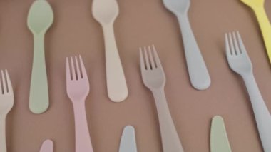 Farklı renklerde yeniden kullanılabilir plastik çatal bıçak seti mutfak masasında çatal bıçak.