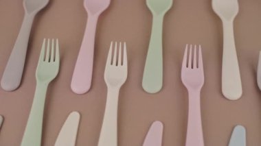 Farklı renklerde yeniden kullanılabilir plastik çatal bıçak seti mutfak masasında çatal bıçak.