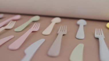 Farklı renklerde yeniden kullanılabilir plastik çatal bıçak seti mutfak masasında çatal bıçak.