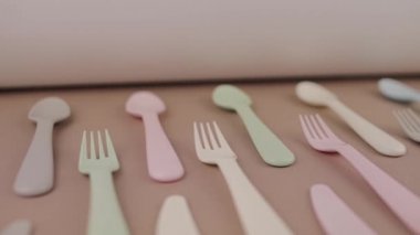 Farklı renklerde yeniden kullanılabilir plastik çatal bıçak seti mutfak masasında çatal bıçak.