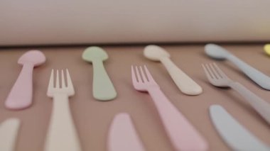 Farklı renklerde yeniden kullanılabilir plastik çatal bıçak seti mutfak masasında çatal bıçak.