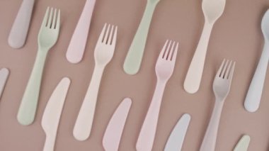 Farklı renklerde yeniden kullanılabilir plastik çatal bıçak seti mutfak masasında çatal bıçak.