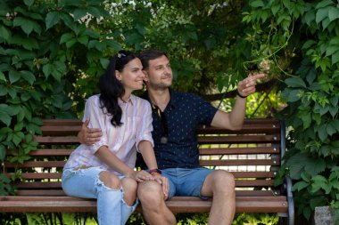 Yazın parktaki bankta oturan bir kızla oturan adam.